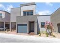 Modern two-story home with a gray exterior, attached garage, and small landscaped yard at 1799 Passerine St, Las Vegas, NV 89138