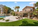 Resort-style backyard with a pool, covered patio, lounge chairs, and meticulous landscaping at 1990 Freeman Ct, Henderson, NV 89014