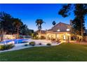 Lush backyard oasis featuring a sparkling pool, covered patio, and well-maintained landscaping at 1990 Freeman Ct, Henderson, NV 89014