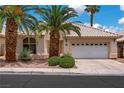 Single-story house featuring desert landscaping, a white garage door, and palm trees set in front of a blue sky at 2149 Eaglepath Cir, Henderson, NV 89074