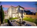 Beautifully landscaped backyard with manicured lawn, patio furniture, and exterior view of the home at dusk at 2407 Ridgeline Wash St, Las Vegas, NV 89138