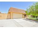 Exterior showcasing an oversized garage, paved driveway, and beautiful landscaping at 2614 Capistrano Ave, Las Vegas, NV 89121