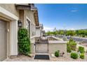 Cozy front patio with desert landscaping, a decorative gate, and comfortable seating for outdoor relaxation at 348 Cadence Vista Dr, Henderson, NV 89011