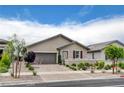 Charming single-story home featuring a well-manicured front yard, desert landscaping, and a two-car garage at 348 Cadence Vista Dr, Henderson, NV 89011