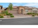 Inviting single-story home with a paver driveway, desert landscaping, and a two-car garage at 398 Frank Case Ln, Henderson, NV 89011