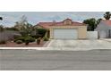 Single-story home with red tile roof, a two-car garage, and a well-kept front yard at 4013 Extenso Dr, North Las Vegas, NV 89032