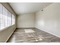 Bright living room featuring wood-look floors and natural light from large windows at 5132 Springland St, Las Vegas, NV 89146