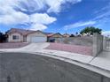Street view of home showcasing desert landscaping, concrete driveway, and partial brick wall at 5217 Yellow Dawn Ct, Las Vegas, NV 89130
