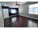Spacious living room with high ceilings, dark accent wall, wood flooring, and abundant natural light at 5217 Yellow Dawn Ct, Las Vegas, NV 89130