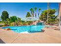 A beautiful swimming pool features a waterfall and multiple palm trees at 5401 Indian Hills Ave, Las Vegas, NV 89130