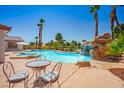 A luxurious outdoor living space features a pool with waterfall and patio furniture at 5401 Indian Hills Ave, Las Vegas, NV 89130