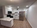 Modern kitchen boasts stainless steel appliances, white cabinetry, quartz countertops and an eat-in island at 5920 Glen Eagles Ln, Las Vegas, NV 89108