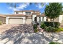 Stunning two-story home featuring a three-car garage, well-manicured lawn, and beautiful architectural details at 606 Cadence Vista Dr, Henderson, NV 89011