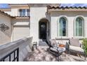 Charming front porch with comfortable seating, textured walls, and views of the landscaped yard at 606 Cadence Vista Dr, Henderson, NV 89011