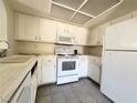 Close-up view of the kitchen with white appliances, cabinets and tile flooring at 6137 W Oakey Blvd # A, Las Vegas, NV 89146