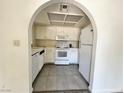 View of the kitchen featuring white appliances and cabinetry, complete with tile flooring at 6137 W Oakey Blvd # A, Las Vegas, NV 89146