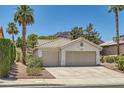 Well-maintained single-story house with a two-car garage, desert landscaping, palm trees, and a mountain in the background at 735 Wolf Point St, Henderson, NV 89002