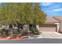 Charming single-story home with a well-maintained yard and mature tree providing shade at 7820 Milkweed Ct, Las Vegas, NV 89149