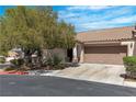 Single-story home featuring a well-manicured lawn, desert landscaping, and a two-car garage at 7820 Milkweed Ct, Las Vegas, NV 89149