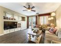 Cozy living room with built-in shelving, ceiling fan, and sliding glass doors to the backyard at 922 Lloyd George Dr, Henderson, NV 89052