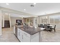 Open-concept kitchen with a granite island, stainless steel appliances, and an adjacent dining area at 1073 Via Della Costrella, Las Vegas, NV 89101