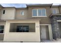 Modern townhome showcasing neutral tones, a covered entry, and contemporary architectural details at 11394 Crimson Ledge Ave, Las Vegas, NV 89138