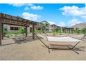 Relaxing hammock area with shaded seating, pergola, lush landscaping, and community gathering space at 11438 Crimson Ledge Ave, Las Vegas, NV 89138