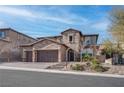 Inviting two-story residence with a stone facade, three-car garage, and beautifully landscaped front yard at 11952 Girasole Ave, Las Vegas, NV 89138
