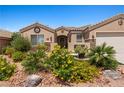 Inviting front yard with mature desert landscaping and decorative stonework surrounding the home's facade at 1309 Vista Del Monte Dr, Mesquite, NV 89027