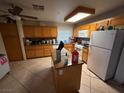 Traditional kitchen with wooden cabinets, an island, and white appliances at 1749 Green Apple Way, Las Vegas, NV 89142