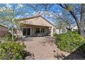 Serene backyard with gravel landscaping, mature trees, and a covered patio with outdoor seating at 2467 Moonlight Valley Ave, Henderson, NV 89044