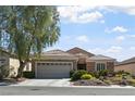 Attractive single-story home showcasing a well-maintained yard, stone accents, and an attached garage at 2467 Moonlight Valley Ave, Henderson, NV 89044