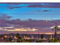 Stunning cityscape view with a vibrant sunset, palm trees, and the Las Vegas skyline in the distance at 2595 Amber Crest St, Las Vegas, NV 89142