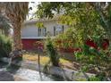 Charming two-story home with white balcony, red trim, and a desert landscape including a small river in front at 2855 Rice St, Logandale, NV 89021