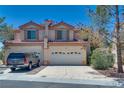 Charming two-story home with a red-tile roof, lush landscaping, and spacious driveway at 4487 Tomer Ln, Las Vegas, NV 89121