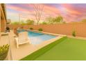 Lush outdoor space featuring a pool, hot tub, and artificial turf area perfect for entertaining and relaxation at 5616 Silver Cascade Ave, Las Vegas, NV 89131