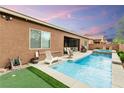 Sparkling pool and spa create a backyard paradise, complete with lounge chairs and a putting green at 5616 Silver Cascade Ave, Las Vegas, NV 89131