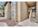 Beige stucco two-story home with a stairs to the entryway at 7200 Pirates Cove Rd # 2084, Las Vegas, NV 89145