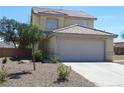Beige two story home featuring a tile roof, two car garage and low maintenance landscaping at 730 Goshawk St, Henderson, NV 89015
