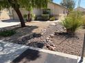 Charming one-story house with low-maintenance desert landscaping in the front yard, featuring rock features and mature foliage at 732 Goshawk St, Henderson, NV 89015