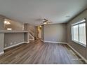 Spacious living room featuring hard wood floors, large window, and ceiling fan at 10279 Montes Vascos Dr, Las Vegas, NV 89178