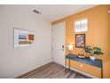 Modern entryway with a stylish console table and artwork on the orange accent wall at 1201 Dre Harbor Pl # Lot 80, North Las Vegas, NV 89084