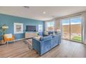 Inviting living room features a plush blue sofa and sliding doors to the backyard at 1201 Dre Harbor Pl # Lot 80, North Las Vegas, NV 89084