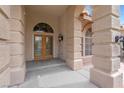 Close-up of the front door framed with stone pillars and transom window above at 1312 Fragrant Spruce Ave, Las Vegas, NV 89123