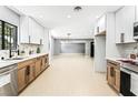 Bright kitchen offers open layout to living area, featuring white cabinets and modern stainless steel appliances at 1415 Helen Ave, North Las Vegas, NV 89030