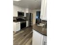 Modern kitchen with stainless steel appliances, granite countertops, and white cabinets at 1502 Cliff Branch Dr, Henderson, NV 89014