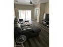 Spacious living room with a large sectional sofa, sliding doors to patio, and hardwood floors at 1502 Cliff Branch Dr, Henderson, NV 89014