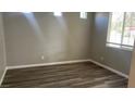Neutral-toned bedroom featuring wood-look floors, base molding, and a window at 1777 Gentle Brook St, North Las Vegas, NV 89084