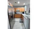 A modern kitchen with stainless steel appliances, wood cabinetry, and gray subway tile backsplash at 23 E Agate Ave # 301, Las Vegas, NV 89123