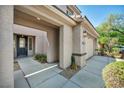 Covered entrance featuring a modern black front door, a light, and a two-car garage at 2449 Daks Loden Ct, Henderson, NV 89044